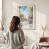 Framed Barcelona Watercolor Wall Art - In Living Room with Woman Looking at it - Portrait