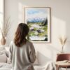 Framed Denali National Park Watercolor Wall Art - In Living Room with Woman Looking at it - Portrait