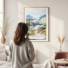 Framed Glacier National Park Watercolor Wall Art - In Living Room with Woman Looking at it - Portrait