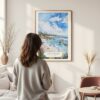 Framed Laguna Beach Coast Watercolor Wall Art - In Living Room with Woman Looking at it - Portrait