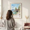 Framed Lake Tahoe Cabin Watercolor Wall Art - In Living Room with Woman Looking at it - Portrait