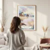 Framed Oregon Coast Watercolor Wall Art - In Living Room with Woman Looking at it - Portrait