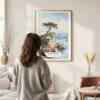 Framed The Lone Cypress Pebble Beach Watercolor Wall Art - In Living Room with Woman Looking at it - Portrait