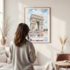 Framed Arc De Triomphe Watercolor Wall Art - In Living Room with Woman Looking at it - Portrait