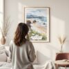 Framed Cannon Beach Oregon Watercolor Wall Art - In Living Room with Woman Looking at it - Portrait