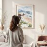 Framed Cannon Beach Oregon Watercolor Wall Art - In Living Room with Woman Looking at it - Portrait