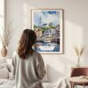 Framed Cape Cod Watercolor Wall Art - In Living Room with Woman Looking at it - Portrait