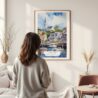 Framed Cape Cod Watercolor Wall Art - In Living Room with Woman Looking at it - Portrait