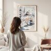 Framed Fairbanks Alaska Winter Watercolor Wall Art - In Living Room with Woman Looking at it - Portrait