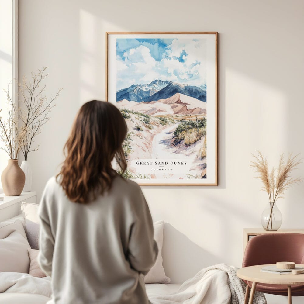 Framed Great Sand Dunes Colorado Watercolor Wall Art - In Living Room with Woman Looking at it - Portrait Framed Great Sand Dunes Colorado Watercolor Wall Art - In Living Room with Woman Looking at it - Portrait
