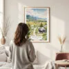 Framed Jackson Hole Wyoming Watercolor Wall Art - In Living Room with Woman Looking at it - Portrait