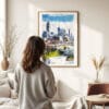 03 - Framed Atlanta Skyline Watercolor Wall Art - In Living Room with Woman Looking at it - Portrait