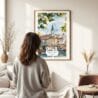 03 - Framed Belgrade Watercolor Wall Art - In Living Room with Woman Looking at it - Portrait