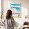 03 - Framed Bondi Beach Watercolor Wall Art - In Living Room with Woman Looking at it - Portrait