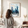 03 - Framed London Business Skyline Watercolor Wall Art - In Living Room with Woman Looking at it - Portrait