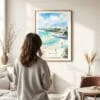 03 - Framed San Diego Beach Watercolor Wall Art - In Living Room with Woman Looking at it - Portrait