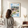 03 - Framed Stockholm Skyline Watercolor Wall Art - In Living Room with Woman Looking at it - Portrait