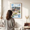 03 - Framed Stockholm Skyline Watercolor Wall Art - In Living Room with Woman Looking at it - Portrait