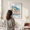 Framed Bergen Norway Waterfront Watercolor Wall Art - In Living Room with Woman Looking at it - Portrait