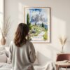 Framed Dolomites Hiking Watercolor Wall Art - In Living Room with Woman Looking at it - Portrait