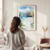 Framed La Jolla Beach Watercolor Wall Art - In Living Room with Woman Looking at it - Portrait