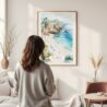 Framed La Jolla Cove Watercolor Wall Art - In Living Room with Woman Looking at it - Portrait