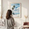 Framed Los Angeles Beach Watercolor Wall Art - In Living Room with Woman Looking at it - Portrait