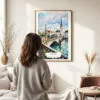 03 - Framed Zurich Switzerland Watercolor Wall Art - In Living Room with Woman Looking at it - Portrait.jpg