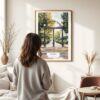 03 - Framed Athens Georgia Arch Watercolor Wall Art - In Living Room with Woman Looking at it - Portrait.jpg