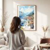 03 - Framed Kontor Montenegro Watercolor Wall Art - In Living Room with Woman Looking at it - Portrait.jpg