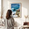 03 - Framed Nazare Portugal Watercolor Wall Art - In Living Room with Woman Looking at it - Portrait.jpg