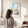 03 - Framed Norwich England Watercolor Wall Art - In Living Room with Woman Looking at it - Portrait.jpg