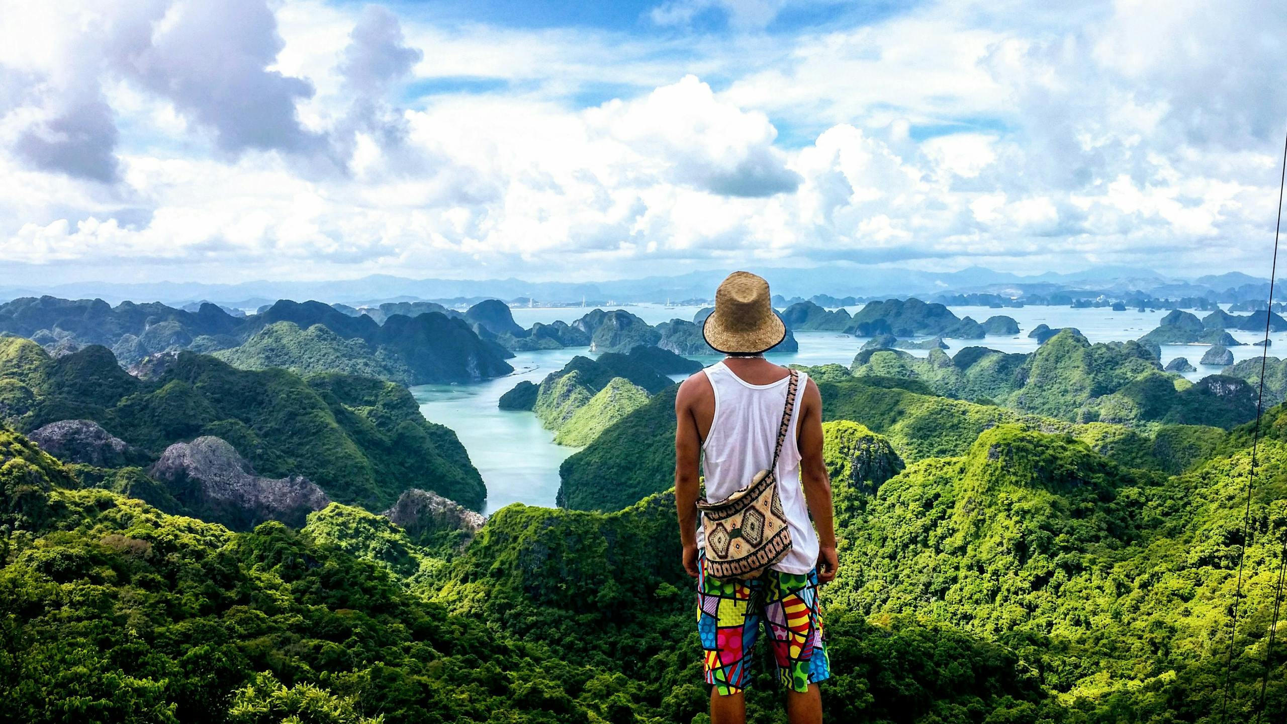 A man enjoys the breathtaking view of Ha Long Bay's lush islands and serene waters.