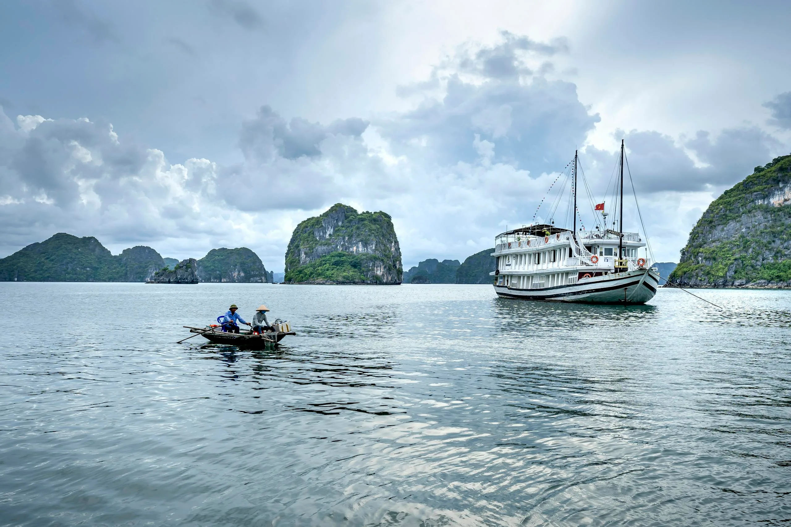 Essential 5-Day Vietnam Itinerary: Explore Vietnam’s Highlights Efficiently 7 A serene view of fishing boats near limestone islands in Ha Long Bay, Vietnam.