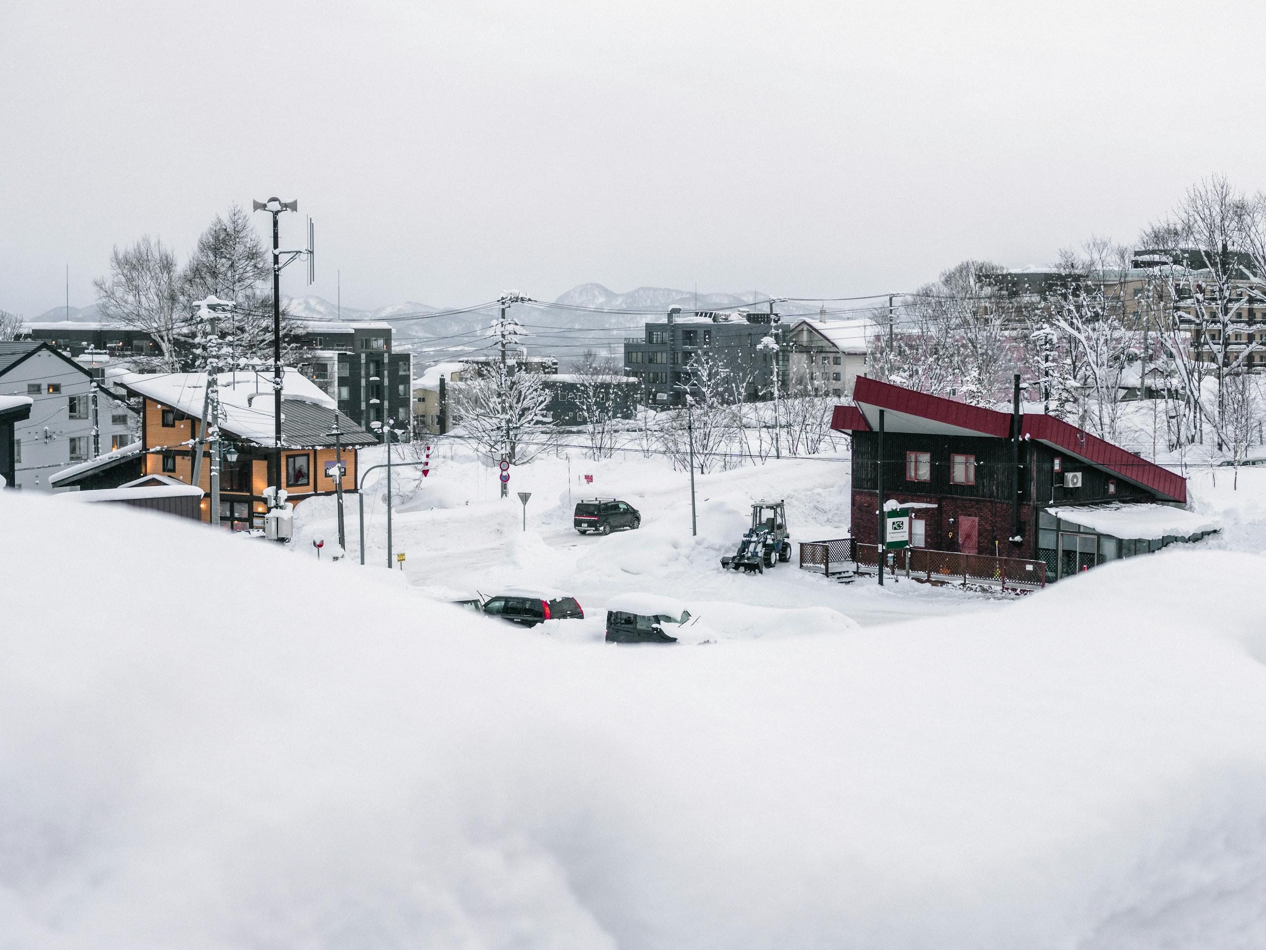 A serene winter scene in snowy Niseko, Hokkaido, showcasing a tranquil village covered in snow.