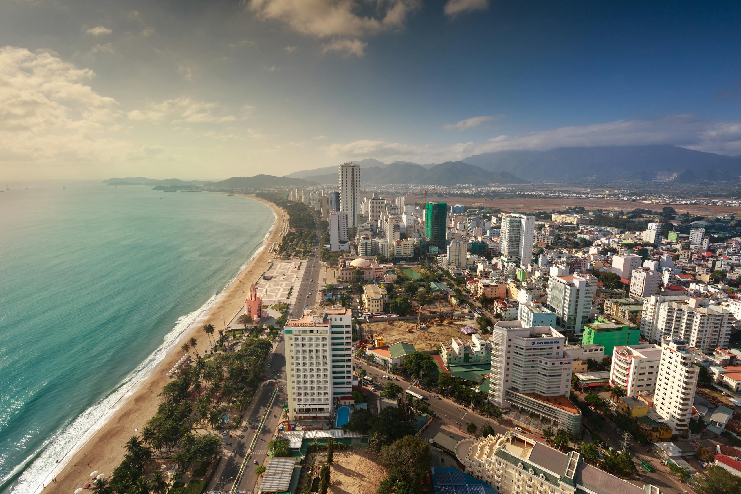 Comprehensive 2-Week Vietnam Travel Itinerary for 2025: North to South Highlights and Planning Tips 1 Aerial view of a coastal cityscape with beach and mountains.