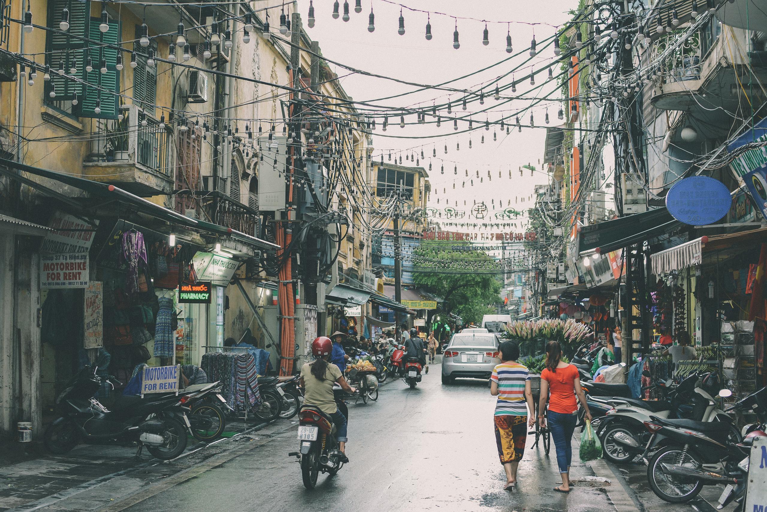Comprehensive 2-Week Vietnam Travel Itinerary for 2025: North to South Highlights and Planning Tips 2 Vibrant street scene in Hanoi's Đống Đa district with bustling markets and motorbikes.