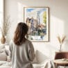 03 - Framed Bruges Belgium Watercolor Wall Art - In Living Room with Woman Looking at it - Portrait.jpg