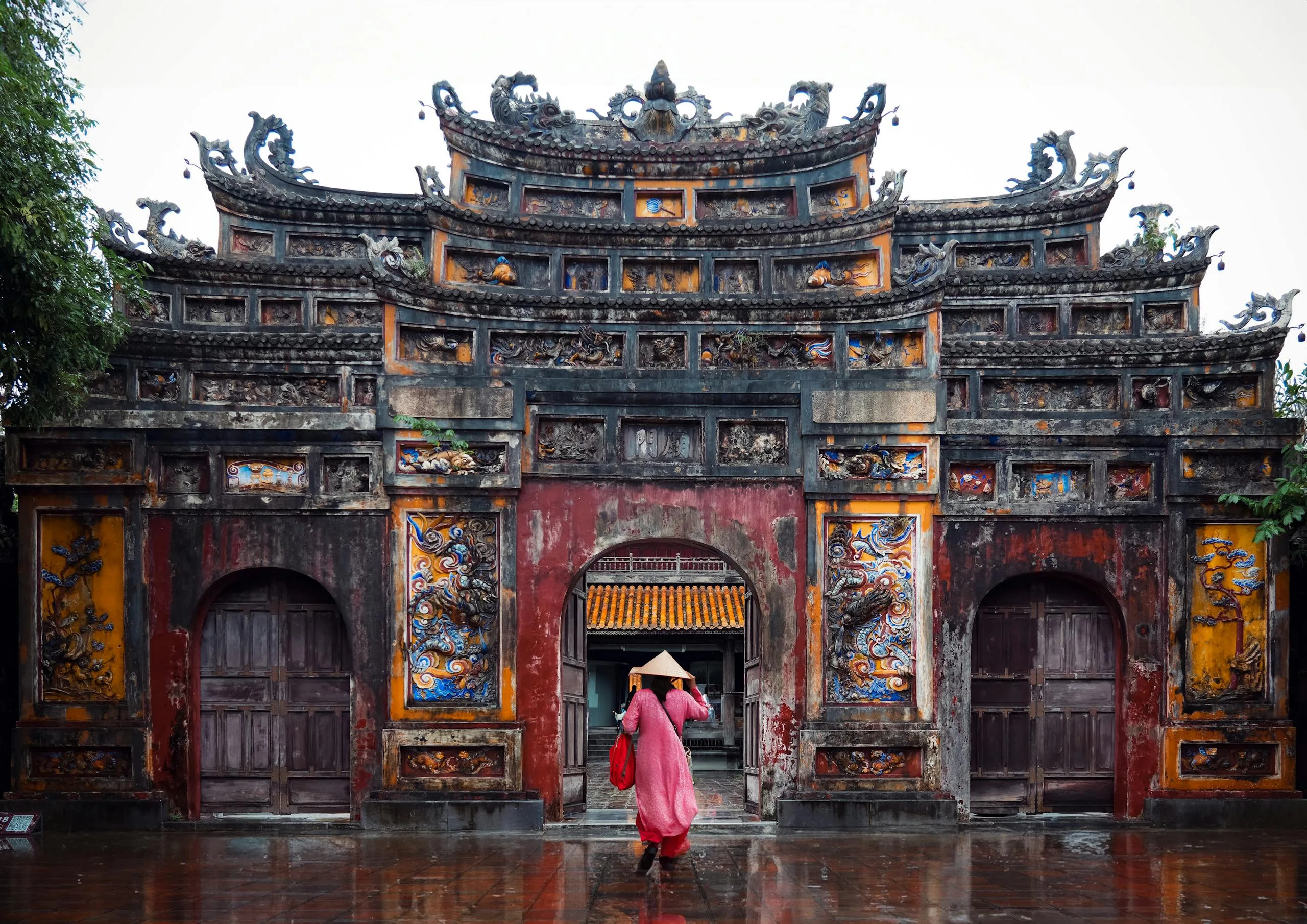 Immersive Cultural Experiences and Royal Cuisine in Hue: A Traveler’s Guide 2025 17 A majestic Vietnamese building with intricate designs in rainy weather.