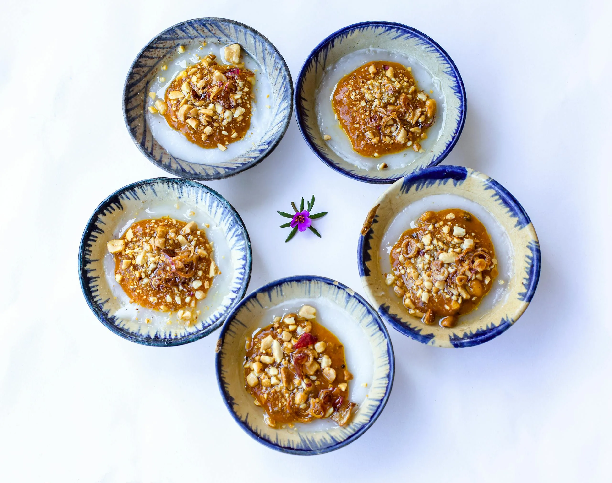 Traditional Vietnamese bánh bèo rice cakes topped with savory nut and shallot mix.