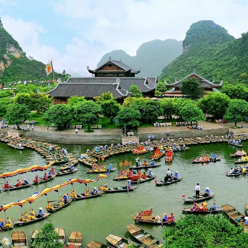 Vibrant boat festival at Trang An with colorful festivities and scenic nature.