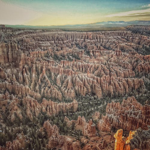 A stunning aerial view of Bryce Canyon's iconic hoodoos under a clear sky at dawn.