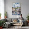 02 - Cape Cod Watercolor Canvas Print with Natural Floater Frame - Woman Knitting on grey couch - Vertical.jpg