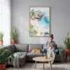 02 - La Jolla Cove Watercolor Canvas Print with Natural Floater Frame - Woman Knitting on grey couch - Vertical.jpg
