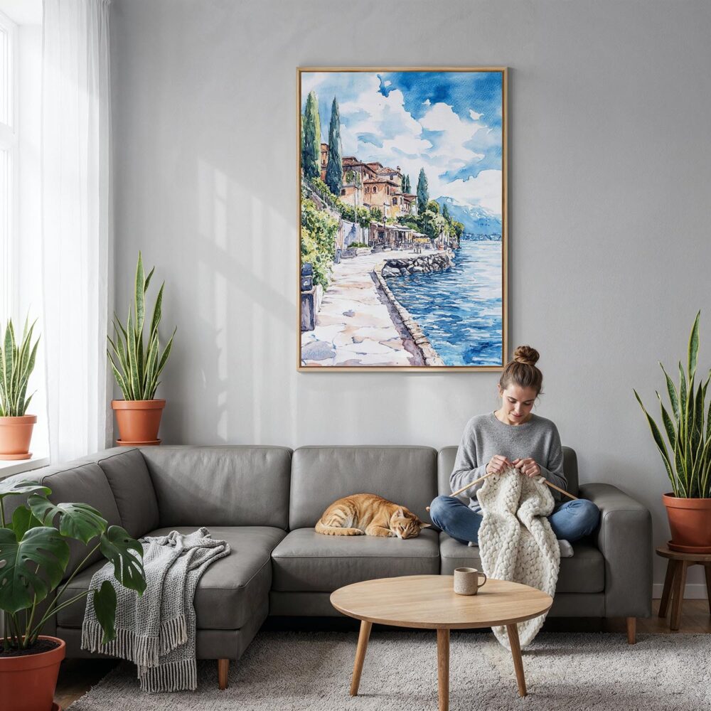 02 - Lake Garda Watercolor Canvas Print with Natural Floater Frame - Woman Knitting on grey couch - Vertical.jpg 02 - Lake Garda Watercolor Canvas Print with Natural Floater Frame - Woman Knitting on grey couch - Vertical.jpg