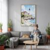 02 - Portland Maine Watercolor Canvas Print with Natural Floater Frame - Woman Knitting on grey couch - Vertical.jpg