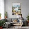 04 - Adirondack Mountains Watercolor Canvas Print with Natural Floater Frame - Woman Knitting on grey couch - Vertical.jpg
