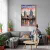 04 - San Diego Skyline Watercolor Canvas Print with Natural Floater Frame - Woman Knitting on grey couch - Vertical.jpg