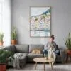 05 - Bergen Norway Houses Watercolor Canvas Print with Natural Floater Frame - Woman Knitting on grey couch - Vertical.jpg