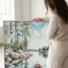 03 - Woman standing next to Large Boundary Waters Square Watercolor Canvas Print with Natural floater Frame.jpg